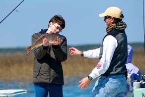 A teenage boy looks at his first red drum