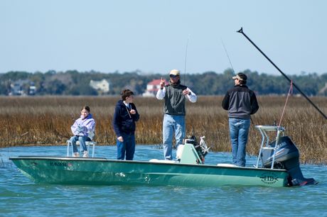 Capt. Legare shows a teenager how to cast a rod for red drum